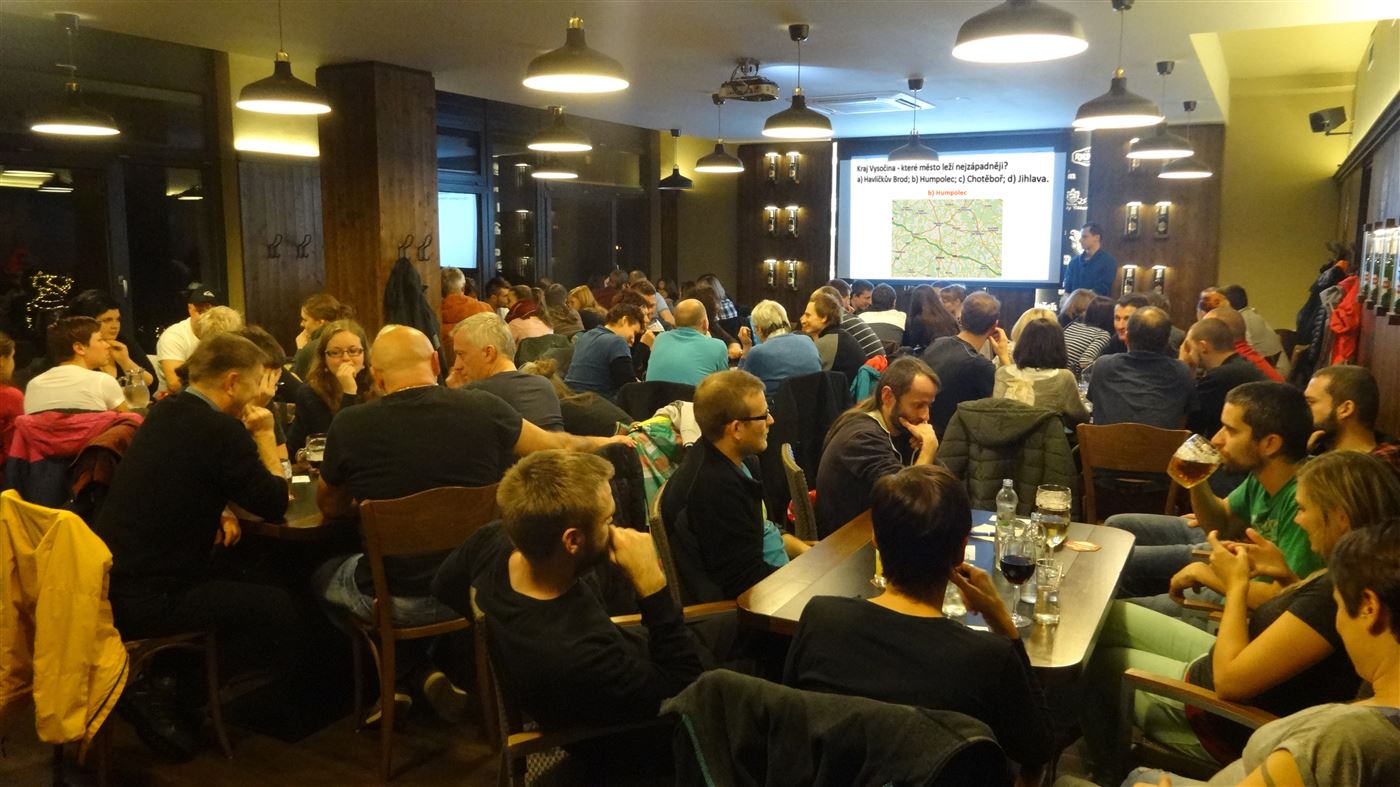 Zaplnený podnik počas Chytrého Kvízu s otázkou na projekcii